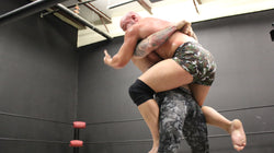 Viking lifts and carries Brute into a bear hug on thunders arena