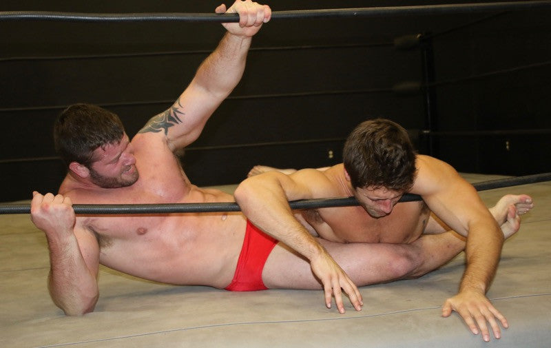 Beast body scissors and chokes Blayne on the ropes at Thunders Arena