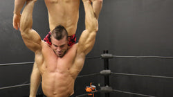 Brian Cage crucifix hold on Bolt bodybuilder huge arms biceps triceps pecs chest abs