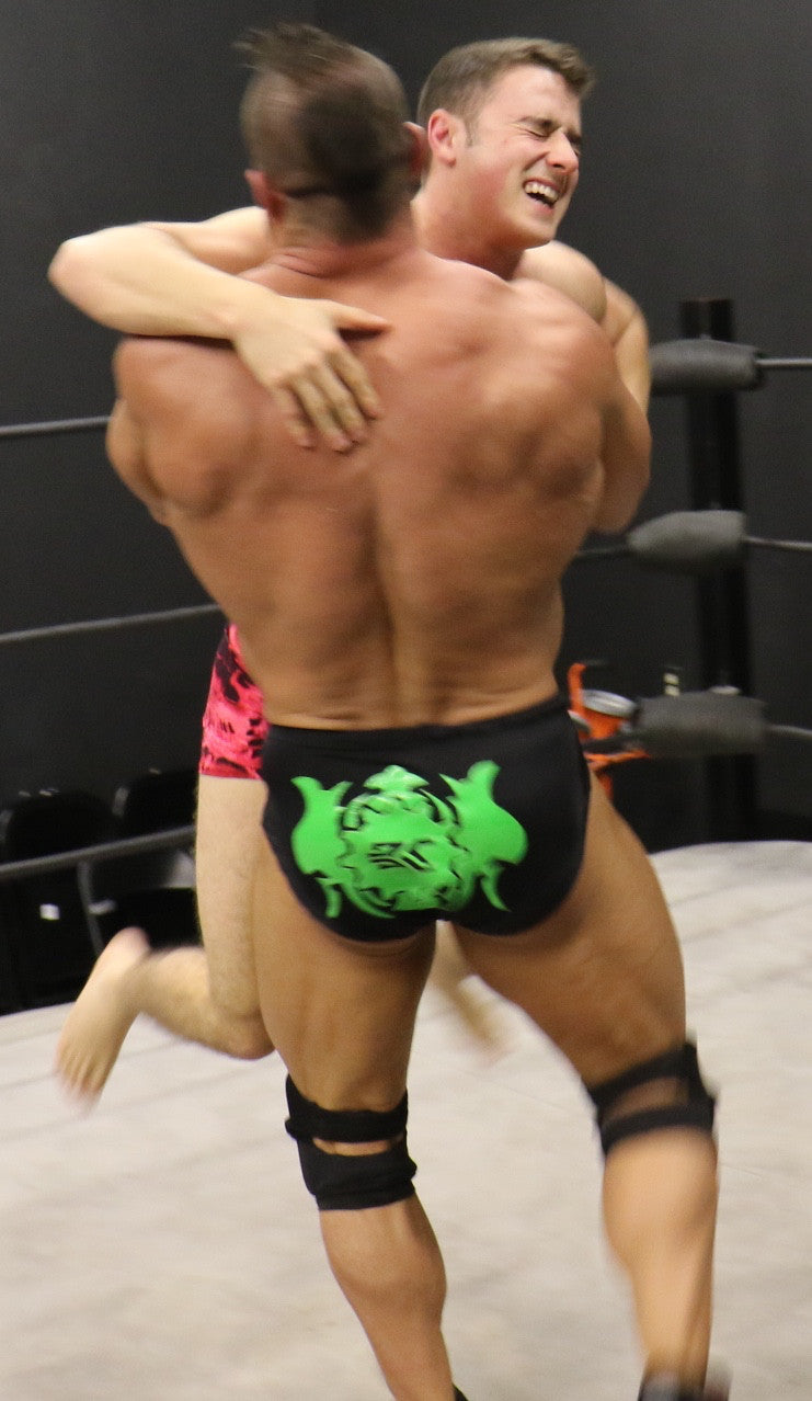 Brian Cage and Bolt grapple in the ring huge back bearhug bear hug