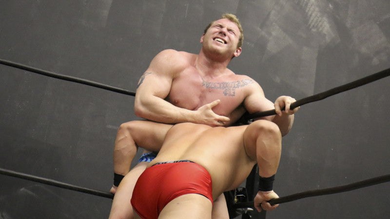 Talon pinned in the corner of the ropes by Bucky