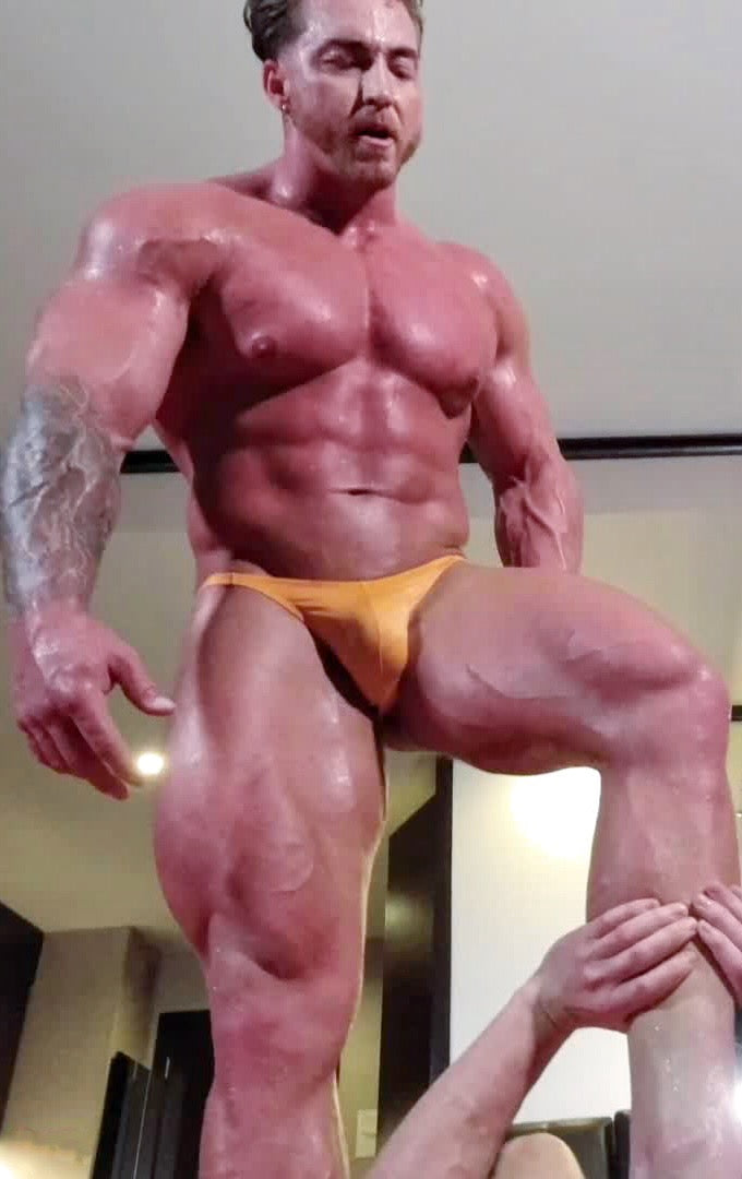 Bodybuilder foot on wrestler's chest